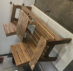 a wooden bench sitting on top of a hard wood floor next to a white wall