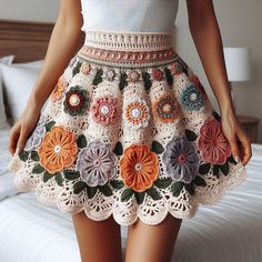 a woman wearing a crocheted skirt with flowers on it