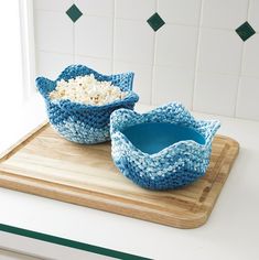 two bowls filled with rice sitting on top of a cutting board