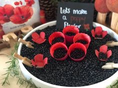 there are some red flowers in the potted planter with little sticks sticking out of it