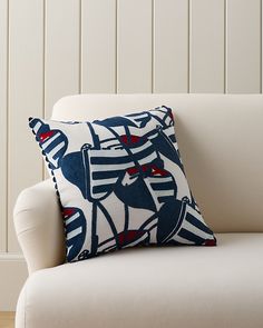 a white chair with a blue and red pillow on it