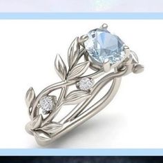 an engagement ring with leaves on it and a blue topazte stone in the center