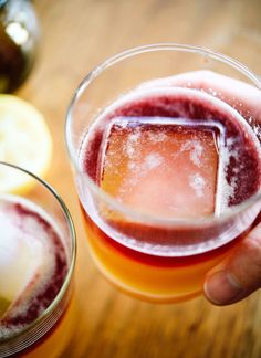 a person holding a glass filled with liquid