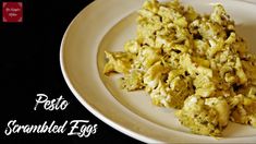 a white plate topped with scrambled eggs on top of a table