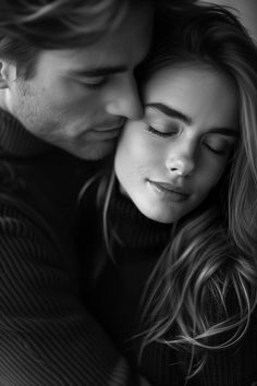 a man and woman cuddle together in black and white