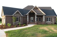 a large brick house with lots of windows and landscaping around it's front entrance