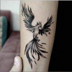 a black and white bird tattoo on the arm