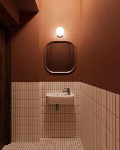 a white sink sitting under a bathroom mirror next to a wall mounted faucet