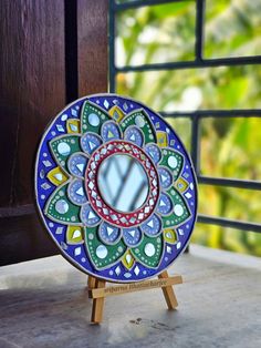 a colorful plate sitting on top of a wooden stand