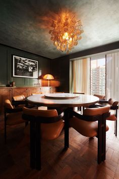 a dining room table with chairs around it and a chandelier hanging from the ceiling