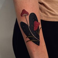 a woman with a tattoo on her arm has mushrooms and leaves in the shape of hearts