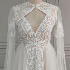 a white wedding dress with sheer sleeves and lace