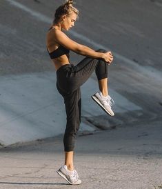 a woman in black sports bra top and leggings doing a kickbox pose