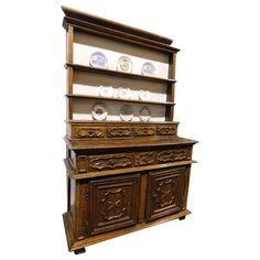 an old wooden china cabinet with plates on the top and bottom shelf, against a white background