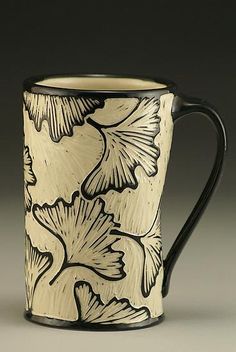 a black and white mug with leaves on it