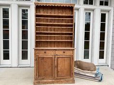 an old wooden bookcase next to a dog bed