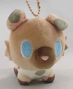 a brown and white stuffed animal with blue eyes on it's face is hanging from a gold chain