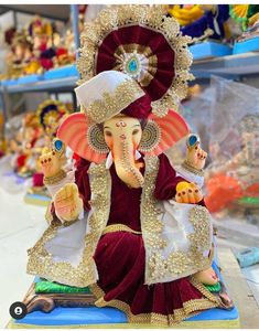 an elephant statue is sitting on a table with other figurines in the background