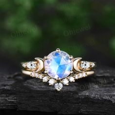 an engagement ring with a large blue stone surrounded by small white diamonds on a piece of wood