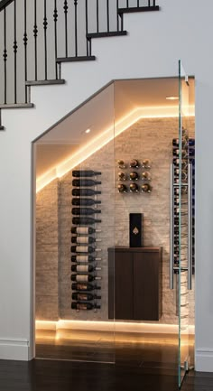 a wine cellar in the middle of a room with stairs leading up to an upper level