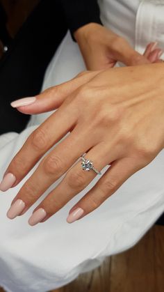 a close up of a person's hand with a wedding ring on their finger