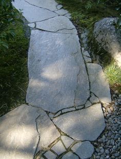 a stone path in the middle of some grass