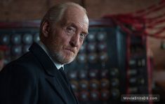 an older man with white hair and beard wearing a suit in a room full of buttons