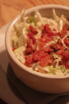 a white bowl filled with coleslaw and bacon