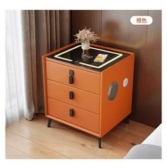 an orange cabinet with drawers and a plant on top