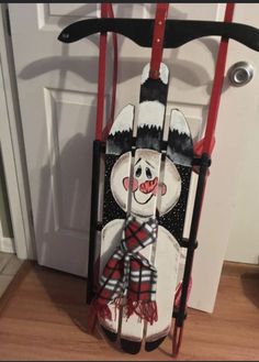 a snowman on a sled is hanging from the door