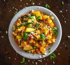 a white bowl filled with food and garnished with parmesan sprinkles