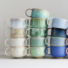 a stack of coffee cups sitting next to each other on top of a white table