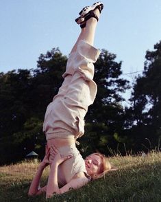 a woman laying on her back in the grass