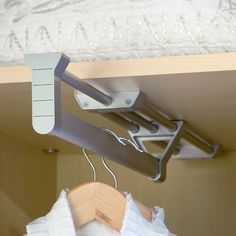 the clothes hangers are attached to the rails on the closet door and there is also a white shirt hanging from the ceiling