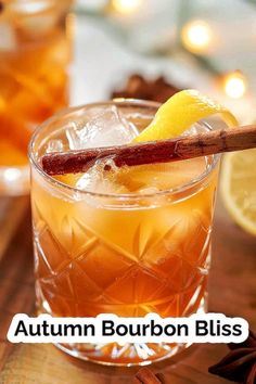 the autumn bourbon bliss cocktail is garnished with an orange slice and cinnamon stick