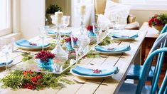 the table is set with blue dishes and place settings