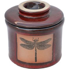 a red jar with a dragonfly on it