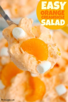 a spoon full of orange cheese salad with marshmallows