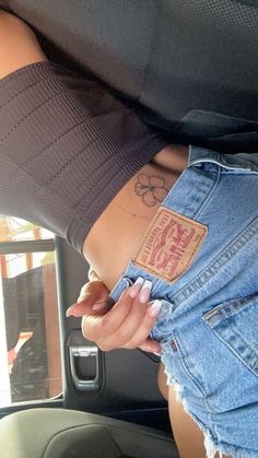 a woman with tattoos on her stomach in the back seat of a car