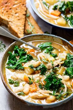 two bowls filled with soup and some bread