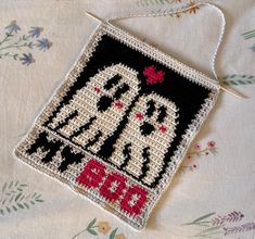 a cross stitch ornament hanging on a table