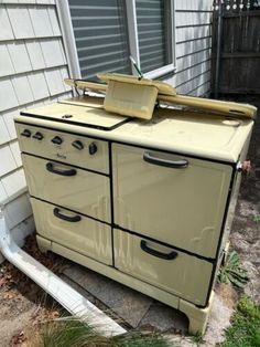 an old fashioned stove sitting in front of a house