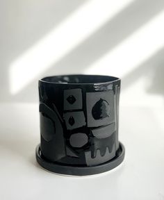 a black and white cup sitting on top of a table