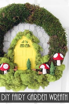 a wreath with moss and mushrooms is hanging on the front door to look like a fairy's house