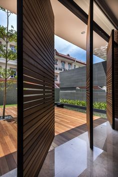 an open room with wooden slats on the wall and wood flooring in front of it