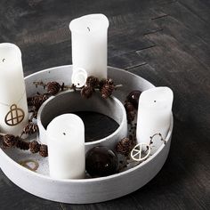 a tray with candles and pine cones in it