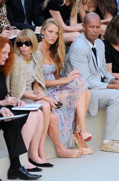 two women and a man sitting next to each other in front of a group of people