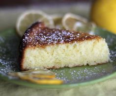 a piece of cake on a green plate with lemons in the backgroud