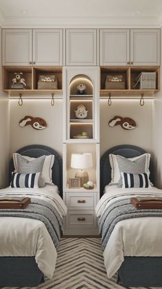 two beds in a room with white walls and wooden shelves above them, along with striped rugs on the floor