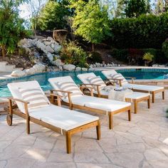 several lounge chairs sitting next to a swimming pool